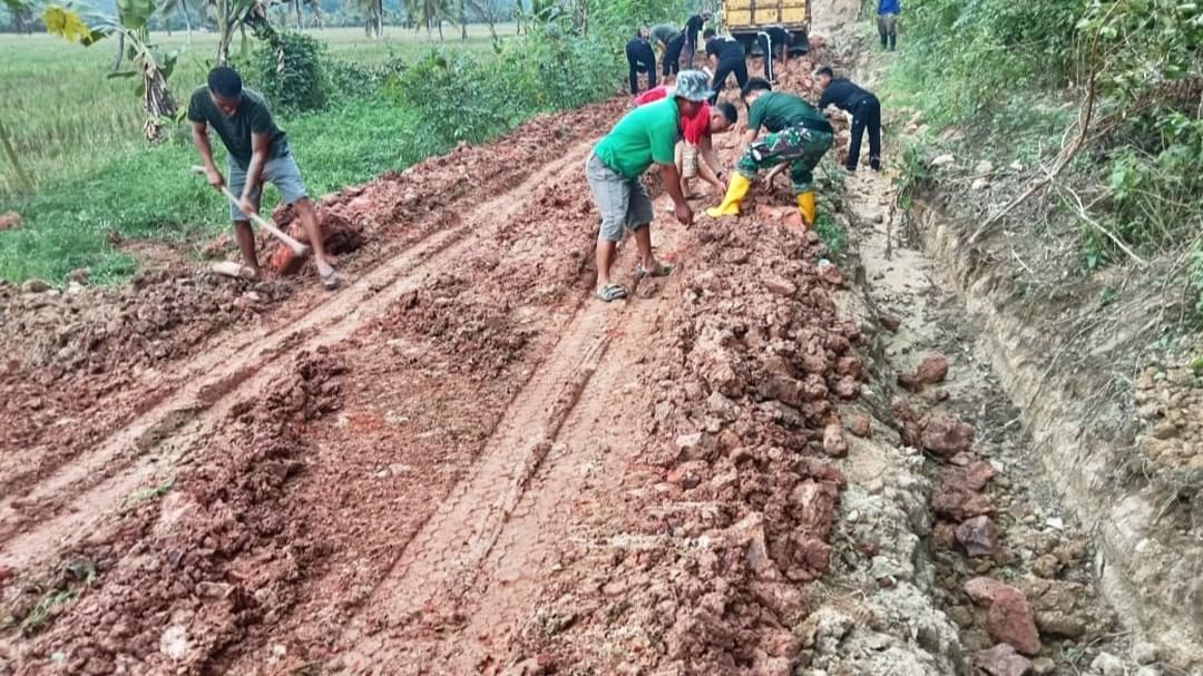 TNI bersama masyarakat Desa Kerta Buana saling bahu membahu menimbun tanah jalan usaha tani dengan bebatuan. (Istimewa)